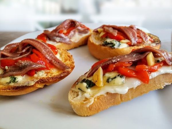 Tostada de queso, anchoa y pimientos